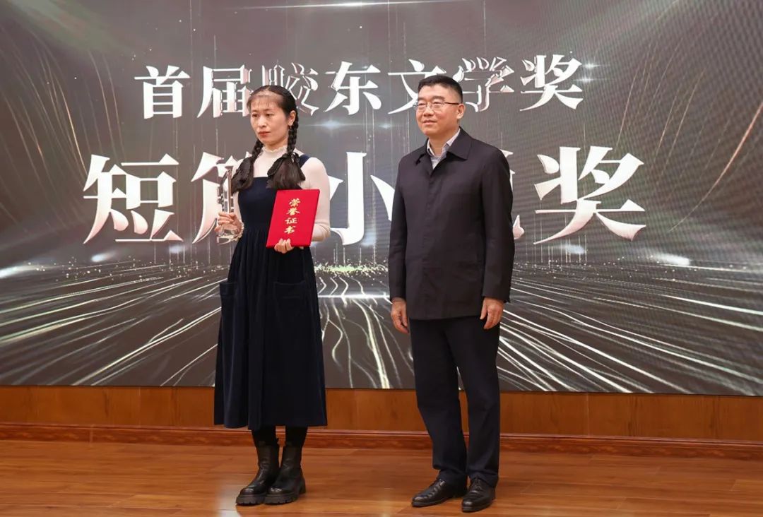 山东省作协党组书记、副主席赵艺丁(右一) 为短篇小说奖获得者王铭婵颁奖